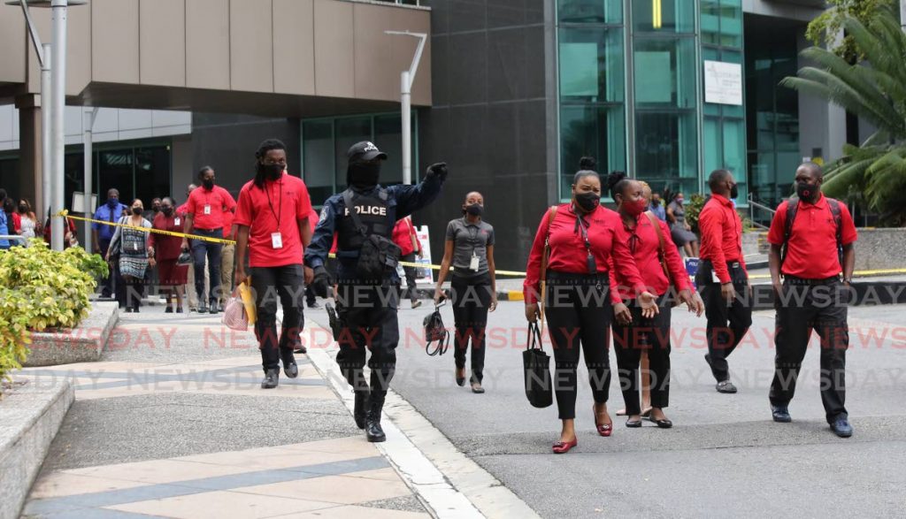 Police escort Parkade workers back to their stations after an all clear was given after police completed checks to the building. - SUREASH CHOLAI