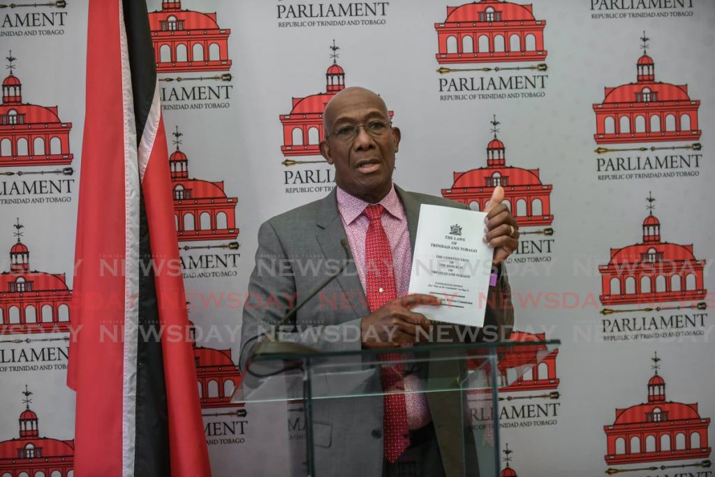 Prime Minister Dr Keith Rowley holds up a copy of the TT Constitution at a Red House press conference on Thursday afternoon as he condemns the behaviour of the Opposition in Parliament earlier that day. - Jeff Mayers