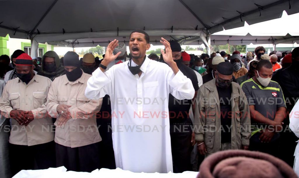 Fuad Abu Bakr leads mourners in prayer during the funeral for his father Yasin Abu Bakr at the Jamaat al Muslimeen mosque on Friday. - PHOTO BY SUREASH CHOLAI