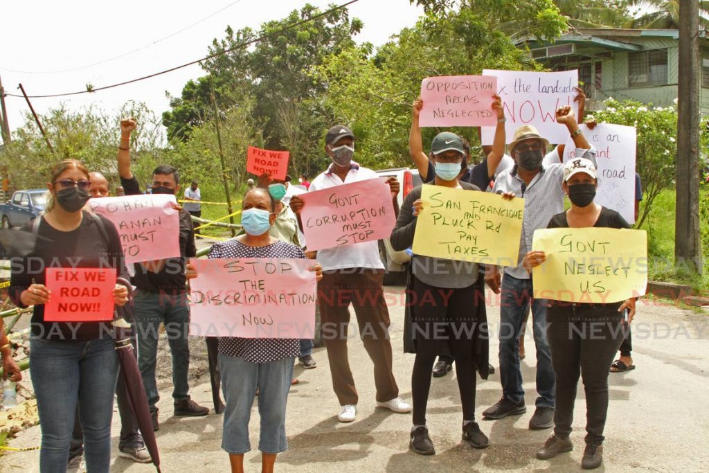 UNC Oropouche West MP Dave Tancoo, at right back (fist in the air) joins San Francique residents and party activists in a protest over road conditions. - Photo by Marvin Hamilton