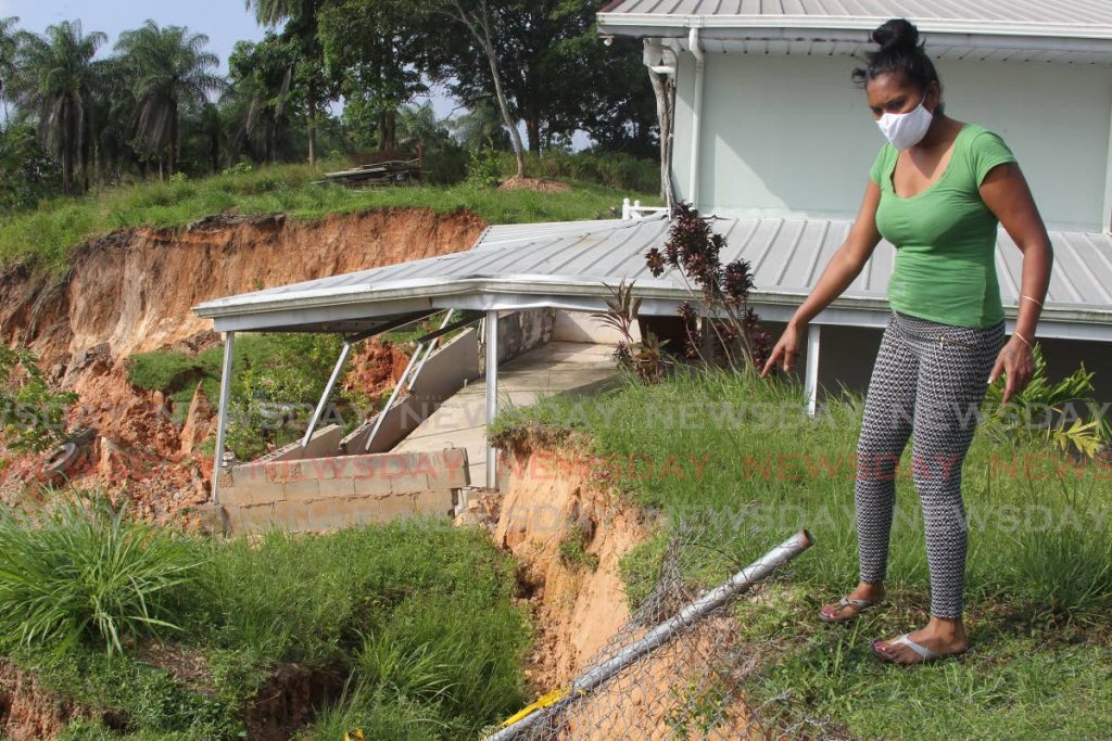 In this file photo, Kamla Harripersad points to land slippage affecting the back portion of her home on Diamond Road, Belle Vue, Claxton Bay on October 29. On September 15, 2021 a major landslide caused by nearby quarrying affected several homes forcing residents to flee their properties. - Photo by Lincoln Holder