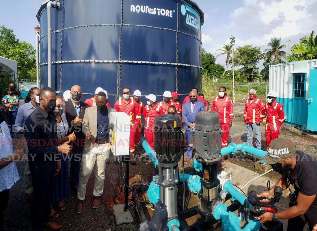 At left, Marvin Gonzales, Public Utilities Minister and Kennedy Richards Jr, MP for Point Fortin, alongside WASA employees and other officials start the pumping apparatus to relaunch the booster station at the La Fortune Water Treatment Plant. - Roger Jacob
