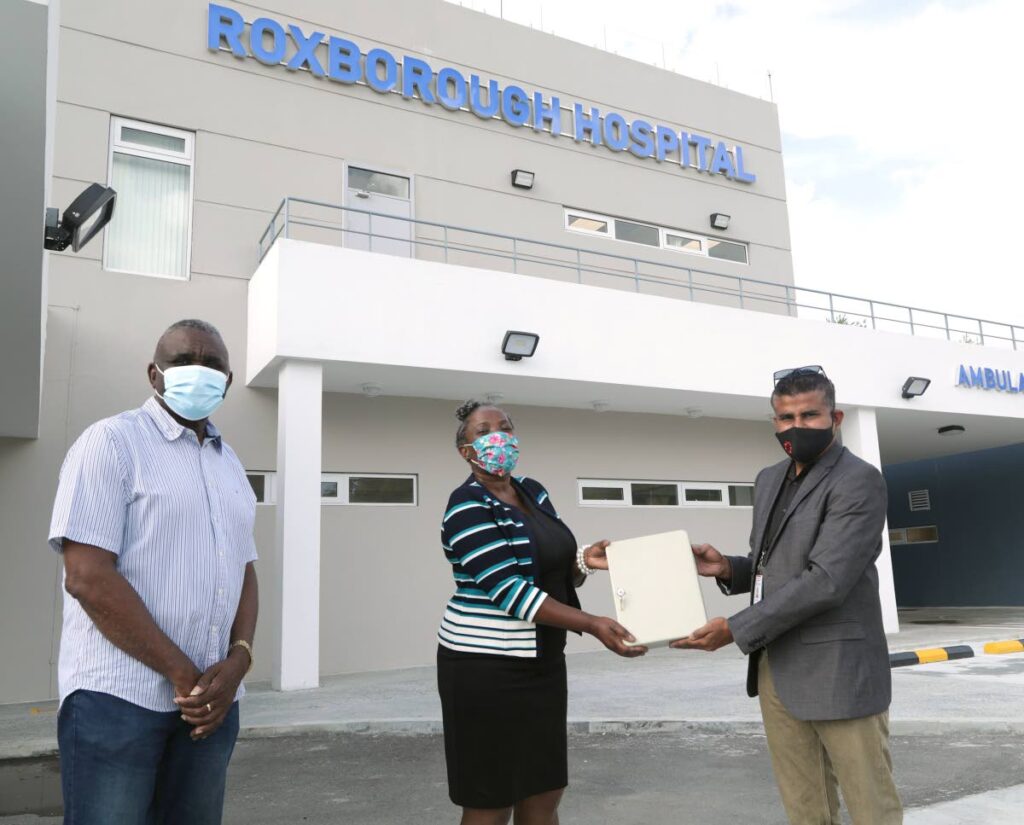 Udecott construction manager Brent Siboo, right, handed over the keys to the Roxborough hospital to Cherryl-Ann Solomon-Mitchell, Administrator, Division of Health, Wellness and Family Development in May. Also present was Westly Orr, interim CEO, TRHA. - THA