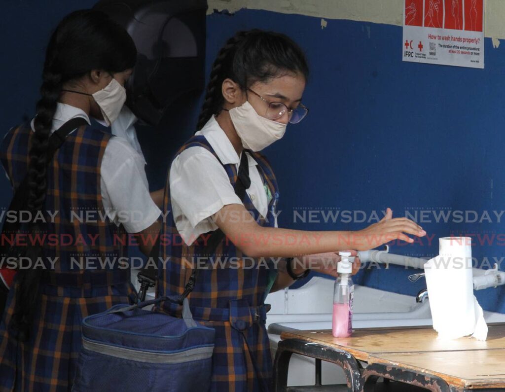 Standard five students of Grant Memorial Presbyterian School, San Fernando, wash their hands on before proceeding to class on July 1. Students were allowed to return to schools to prepare for the SEA exam on August 20.    - File photo/Angelo Marcelle