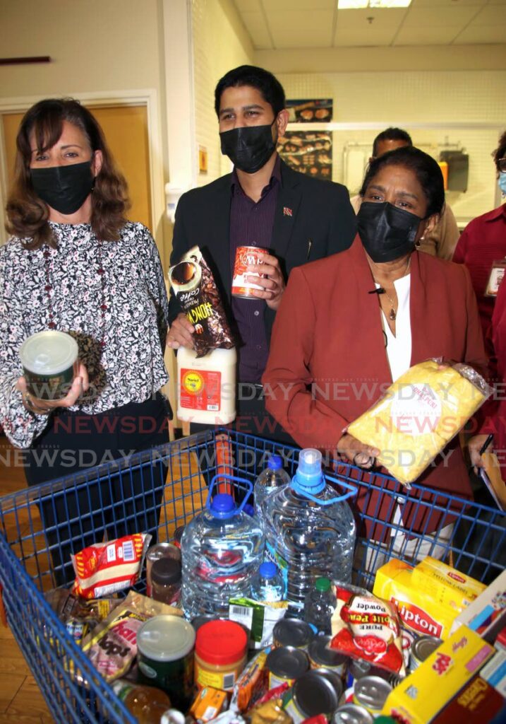 FOOD FOR ALL: Trade and Industry Minister Paula Gopee-Scoon, right, and president of the Supermarkets Association Rajiv Diptee, centre, seen in this photo on a recent tour of Massy Stores in Trincity, both disagreed on Sunday with claims of a gloomy Christmas due to an impending food shortage. 

Photo by Sureash Cholai