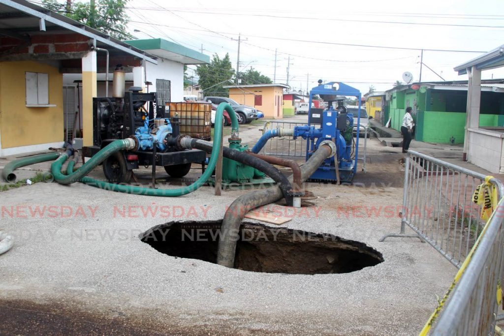Two water pumps have been installed at the site of the sinkhole in Beetham Gardens, in an attempt to remove the excess waste water in the road cavity to start repairing the underground sewage main. - Photo by Roger Jacob