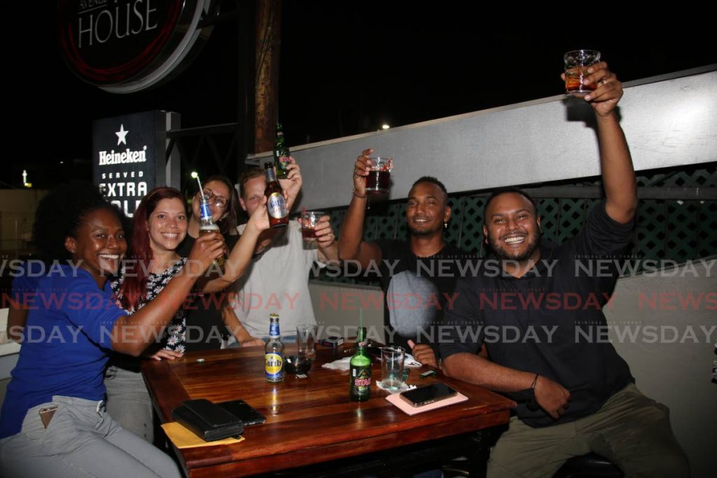Lundi, les clients savourent un citron vert avec des boissons alcoolisées au Pub House Bar sur l'avenue Ariapita à Port of Spain.  - Sureash Cholai