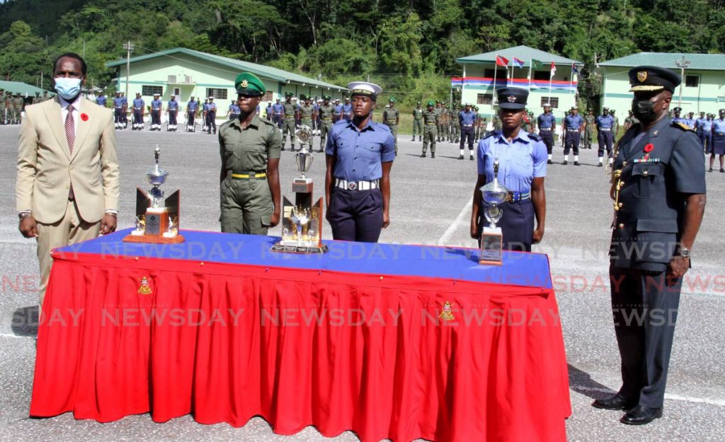 Minister of National Security Fitzgerald Hinds, left, and  Chief of Defence Staff Air Vice Marshal Darryl Daniel stand next to the Best Recruit Female at the Trinidad and Tobago Defence Force joint recruit passing out parade at Teteron Barracks, Chaguaramas, on Tuesday. Photo by Angelo Marcelle