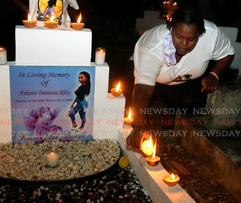 STILL LOVED: Candice Riley, mother of murdered teenager Ashanti Riley, lights deyas and candles at her daughter's grave at the San Juan Cemetery on All Souls Day, Tuesday. - SUREASH CHOLAI