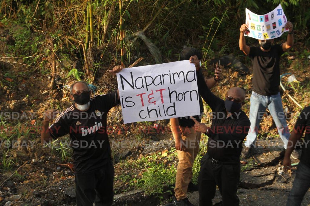 Residents of Realize Road, Princes Town hold placards protesting the state of infrastructure in the Naparima constituency during a protest on November 3. - Photo by Marvin Hamilton