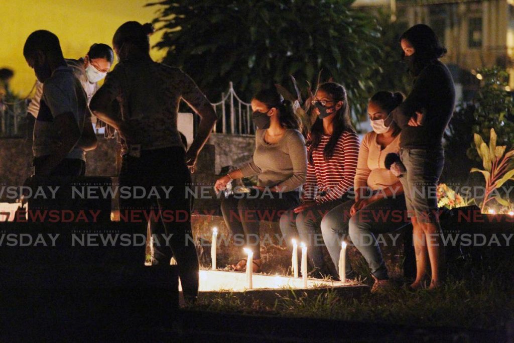 IN LOVING MEMORY: People stand near lighted candles on the graveside of loved ones at the Santa Rosa RC cemetery on Tuesday evening in observance of All Souls. PHOTO BY LINCOLN HOLDER - 