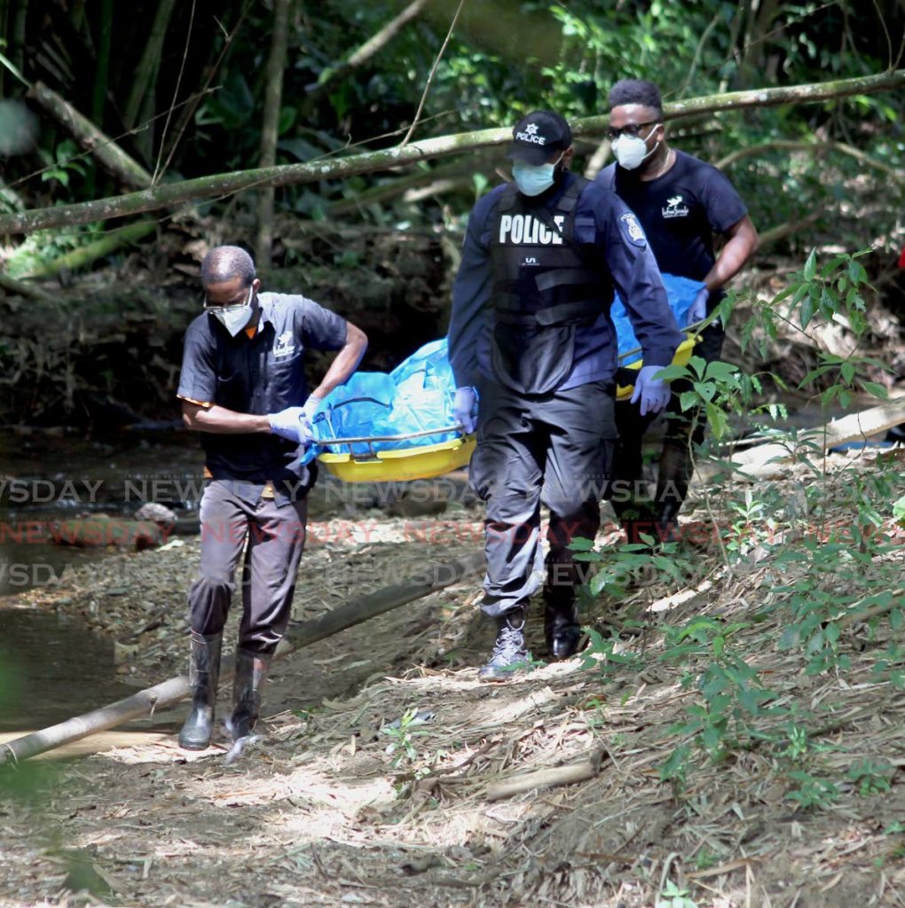 Police officers recover the body of Kezia Jeneka Guerra in a forested area in Maracas St Joseph on November 5. Guerra was reported missing on October 31. FILE PHOTO - 