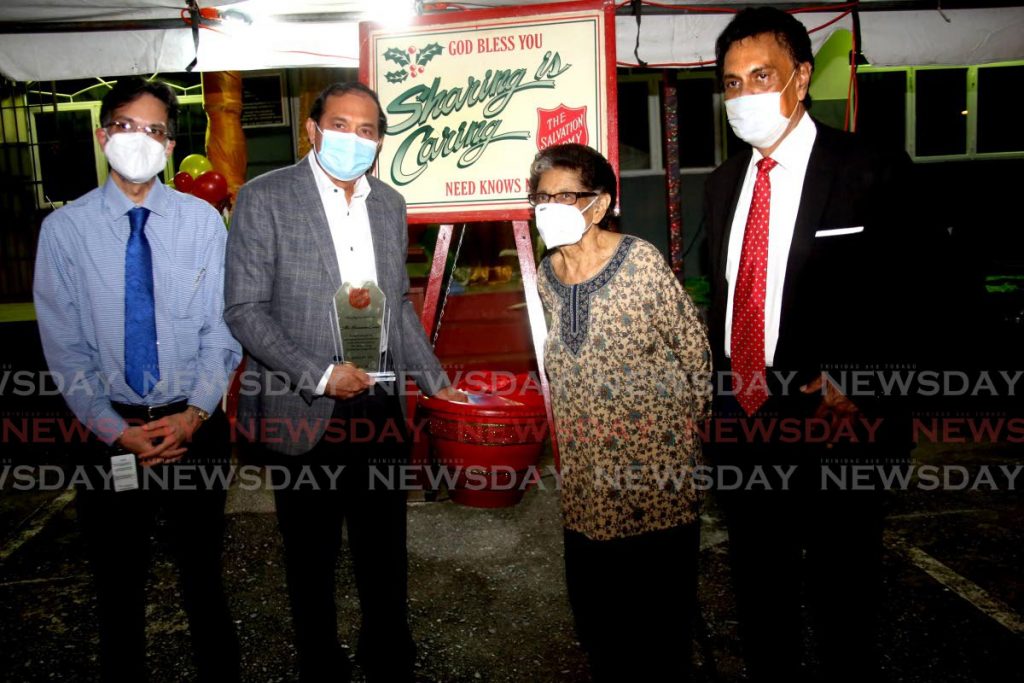 Salvation Army board member, from left, Shivan Bhaggan, Coosal's Group of Companies chairman Sieunarine Coosal, placing the first donation into the Salvation Army Christmas kettle, patron Zalayhar Hassanali, and Salvation Army chairman Bindra Dolsingh duriing the launch at Henry Street, Port of Spain on Friday. - PHOTO BY SUREASH CHOLAI