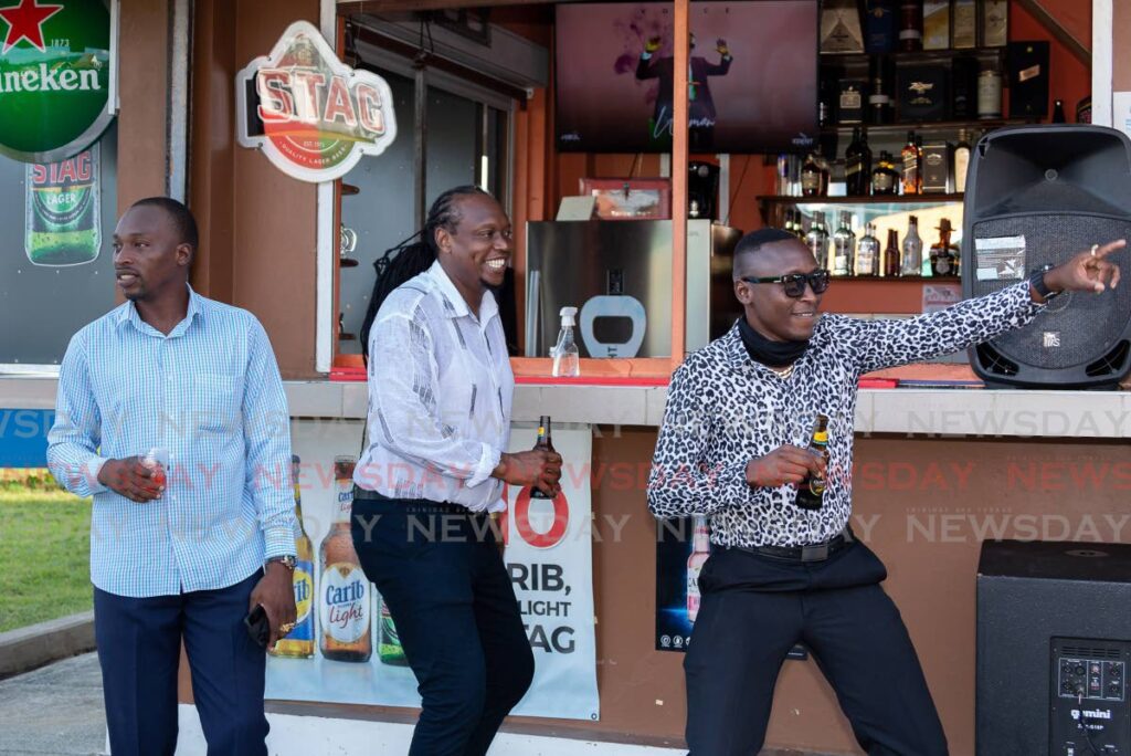 Kevon Otley, left, Lester Thomas, centre, and Mensa Pollard enjoy a lime at Bayside Beer Garden, Esplanade, Scarborough, recently.  - David Reid