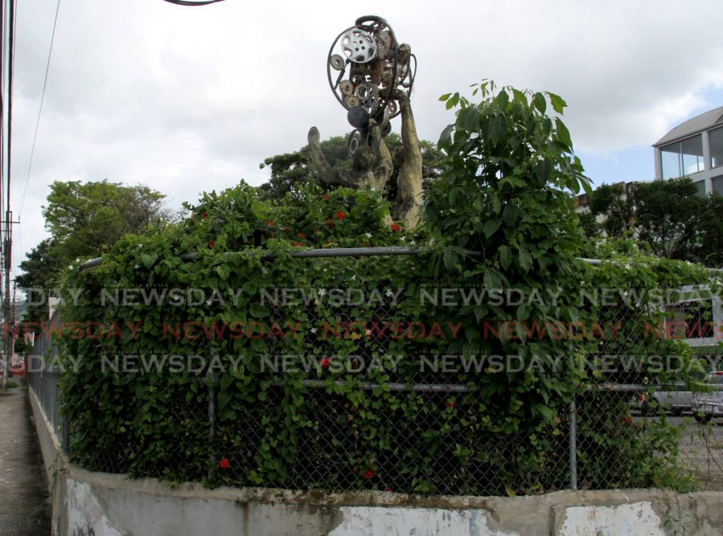 The Pat Chu Foon sculpture Man & Industrialisation is covered with weeds at the LJ Williams car park on the corner of New and St Vincent Streets in Port of Spain. - AYANNA KINSALE