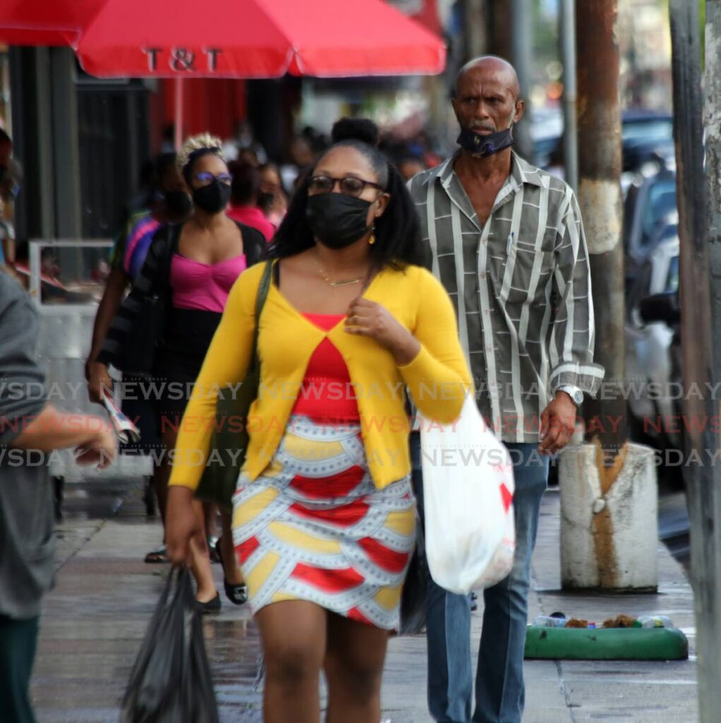 Masked pedestrian go about their business in Port of Spain recently. The Ministry of Health is urging people to make sure their nose and mouth is covered with their masks. - SUREASH CHOLAI
