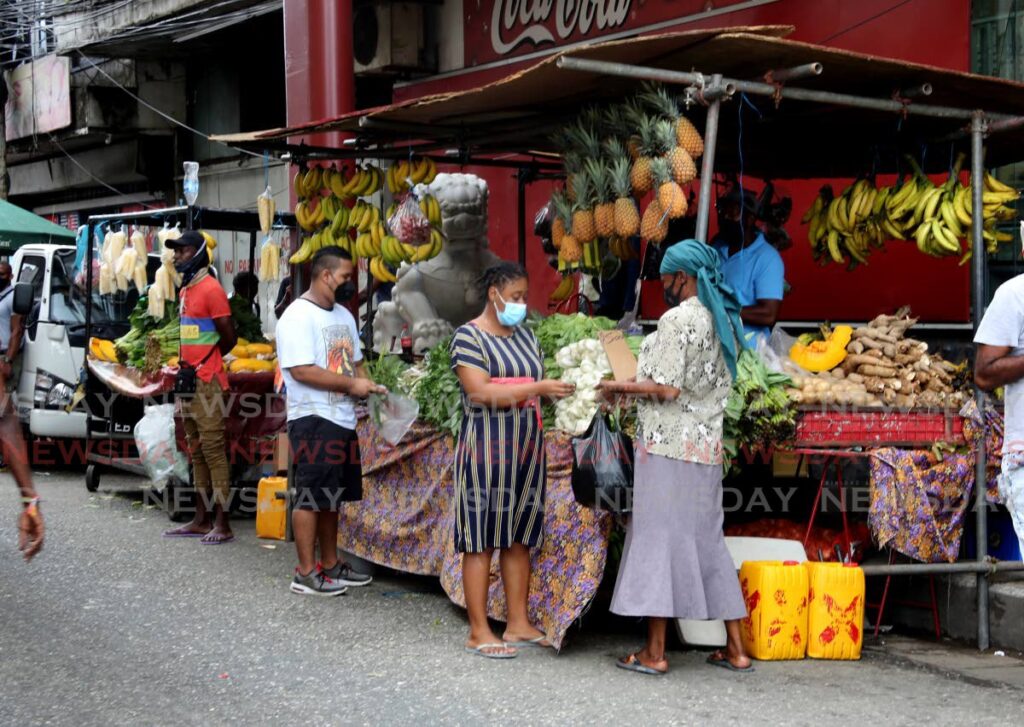 Cutomers shop at fuuit and vegetables vendors along Charlotte Street in Port of Spain on Saturday. - SUREASH CHOLAI