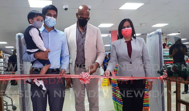 CUT: San Fernando Mayor Junia Regrello, centre, cuts the ribbon on Monday to open the Pennywise San Fernando store at its new outlet on Monday. PHOTO BY LAUREL WILLIAMS
