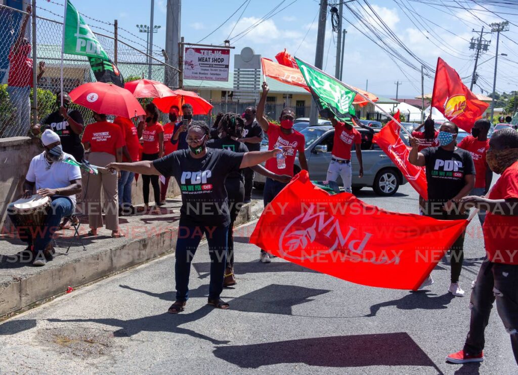 Supporters of the PDP and PNM wave their red and green flags in Calder Hall when candidates of both parties arrive file their nomination papers for the THA election. Photo by David Reid - David Reid