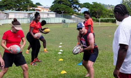 Rugby coach Robin Mac Dowell of Canada (second from right) during a practical demonstration to members of the Tobago rugby club. - 