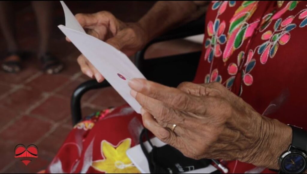 An elderly woman reads her greeting card from the Adopt a Grandpal initiative last year. - 