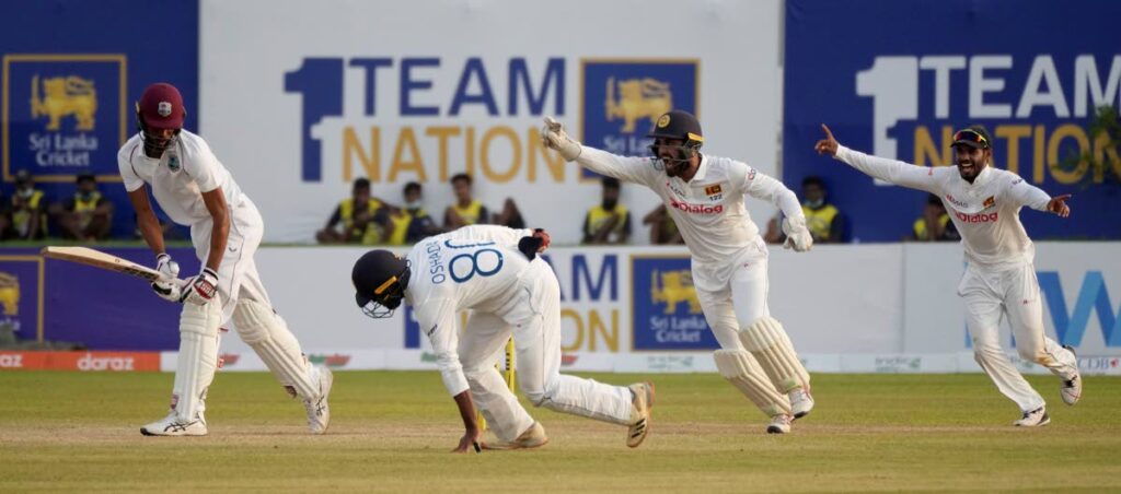 Sri Lanka’s Oshada Fernando, second left, takes a catch to dismiss West Indies’ batsman Roston Chase, left, as wicketkeeper Dinesh Chandimal, and Dhananjaya de Silva celebrate during day two of the first Test in Galle, Sri Lanka, on Monday. AP Photo - 