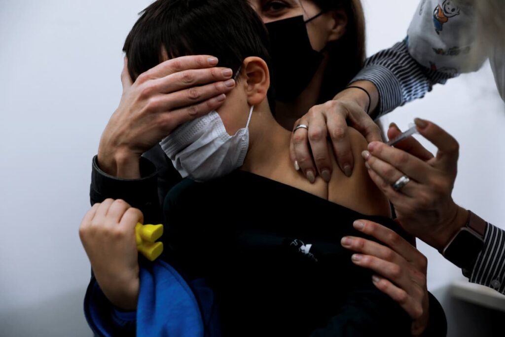 Israeli child Liam Lev Tov, six, in the arms of his mother, receives a Pfizer-BioNTech covid19 vaccine at Clalit Health services in Tel Aviv, Israel, on November 23. Israel has a vaccination campaign for children 5 to 11. In TT, vaccines are only allowed for children 12 and older. - AP Photo
