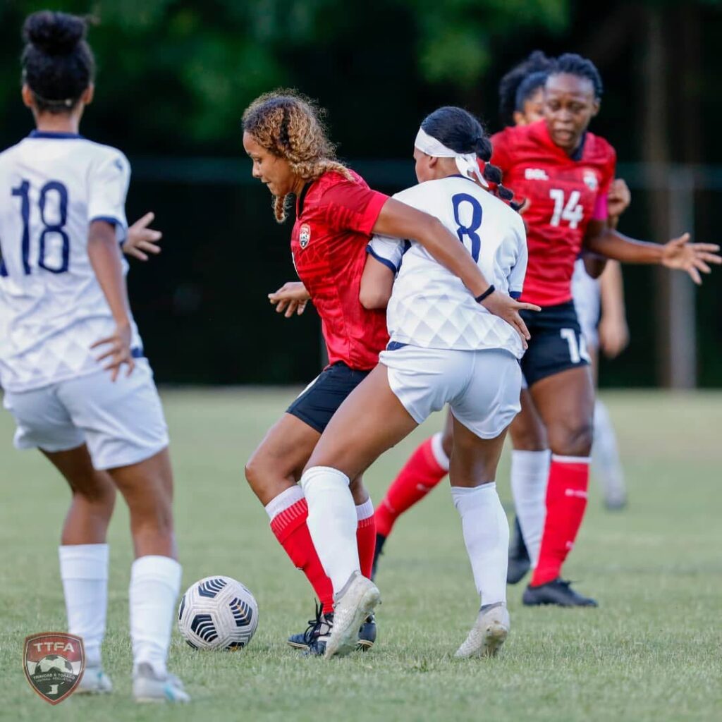 Trinidad and Tobago women's team midfielder Maylee Attin-Johnson (second from left) tries to shield the ball from her Dominican Republic opponent during the teams' friendly football international at San Cristobal, Dominican Republic on Friday. PHOTO COURTESY TTFA. - 