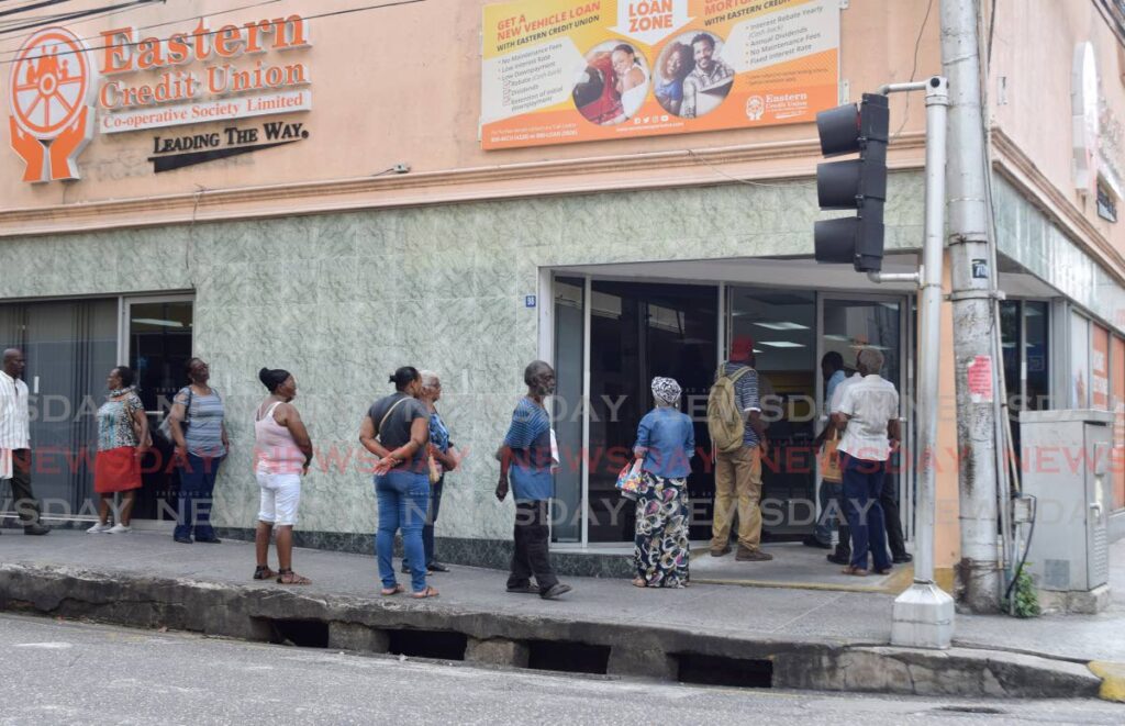 In this file photo, customers line up outside of Eastern Credit Union Park Street, Port of Spain. - Photo by Vidya Thurab