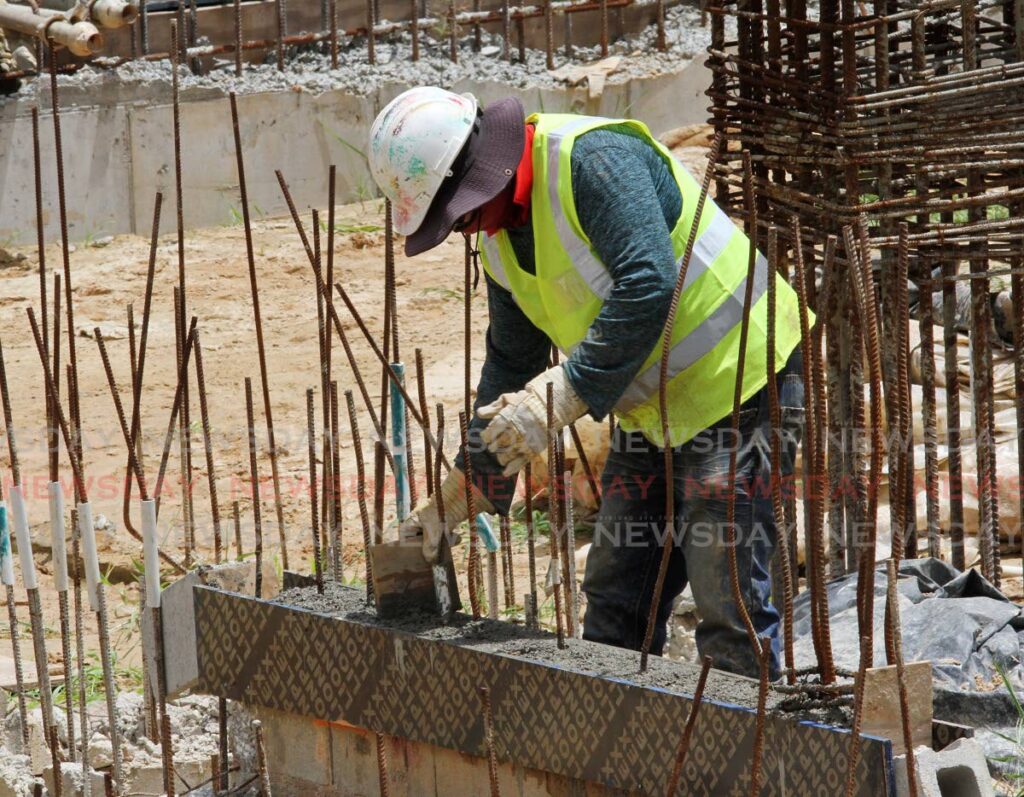 In this file photo, a construction worker evenly distributes cement on a site on Sutton Street, San Fernando. - Angelo Marcelle