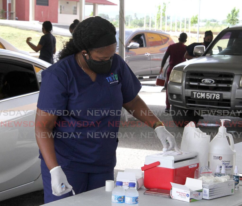 A frontline nurse prepares to vaccinate people against covid19 at a mass drive-thru facility at the Ato Boldon Stadium, Couva. - Angelo Marcelle