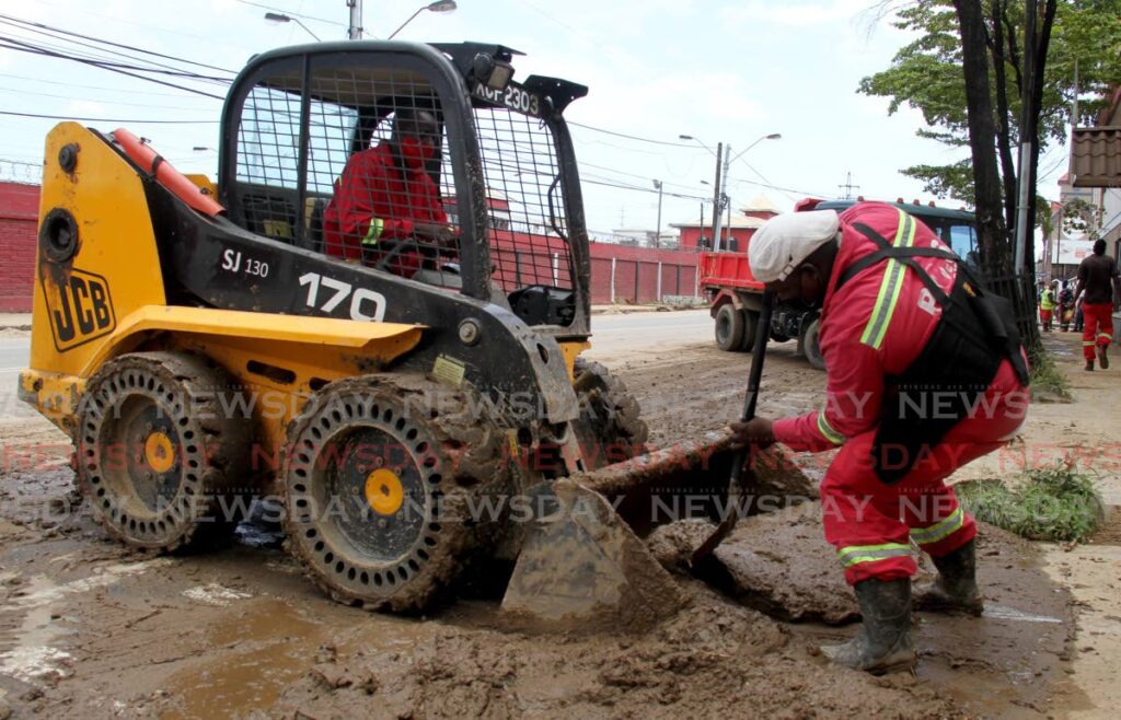 In this file photo, a Port of Spain City Corporation employees helps load slush on a mini-tractor after floods in the captial city. - AYANNA KINSALE