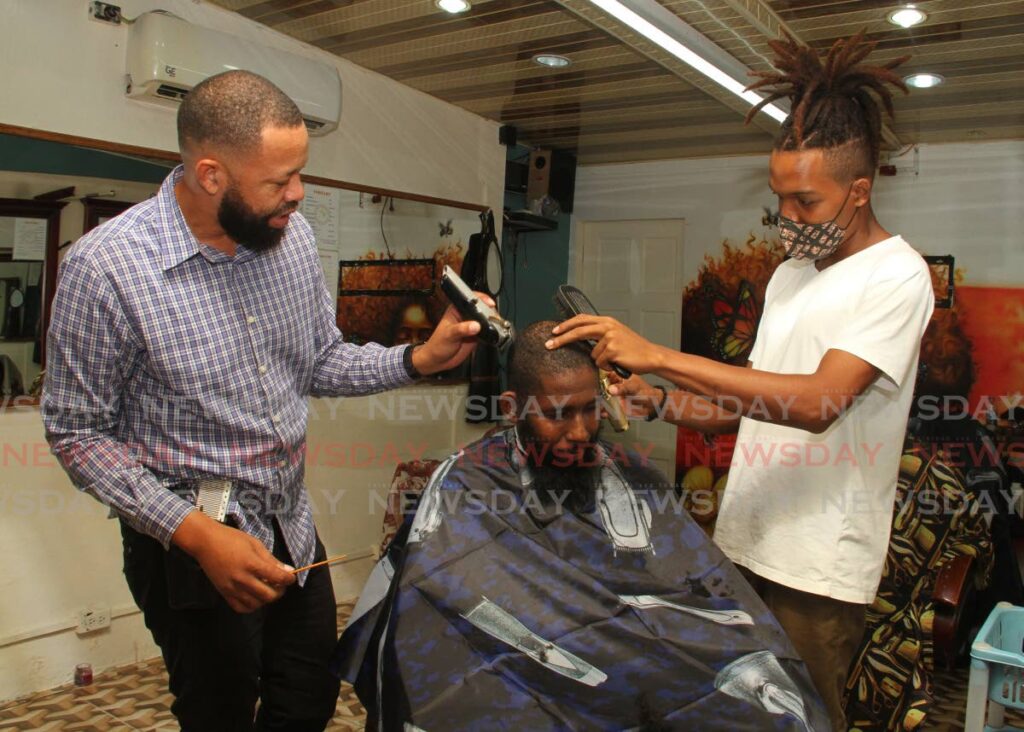 Owner of Chenno Styles Barber Shop, Tauren Christian Meade, left, helps barber Israel ´Toppy´Alleyne attend to customer Andre Mc Leod at the Lord Street, San Fernando location. Reputation matters to all businesses no matter their size. 
File photo/Angelo Marcelle - 