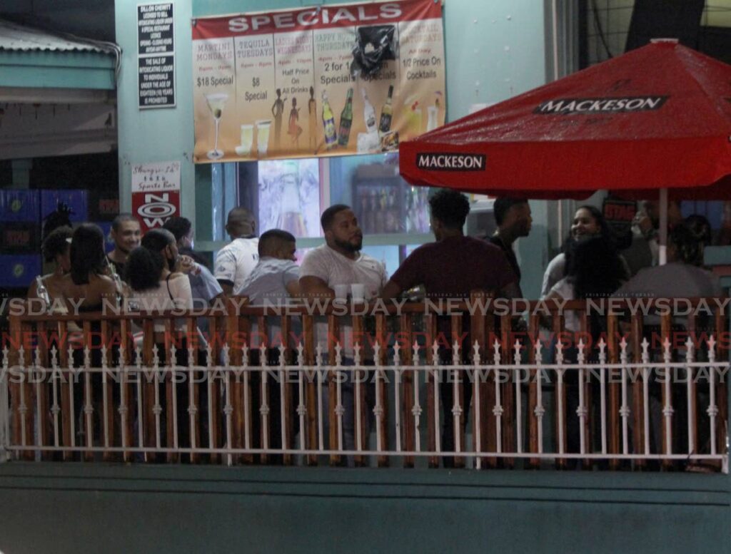 Patrons gather at one of the bars along Ariapita Avenue, Port of Spain, last month after health regulations were rolled out to make them safe zones.  - AYANNA KINSALE