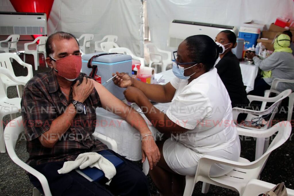 A man receives his third shot of the Sinopharm vaccine at the Courts Megastore compound. - SUREASH CHOLAI