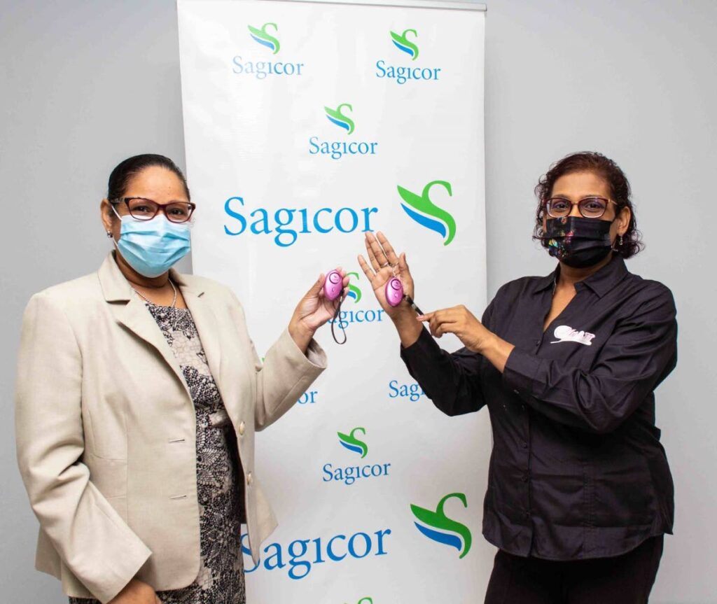 Nathalia Smith, manager, employee relations, payroll and benefits at Sagicor presents Christine Rambarack of the Single Mothers Association with the alarms at Sagicor’s Port of Spain office. - 