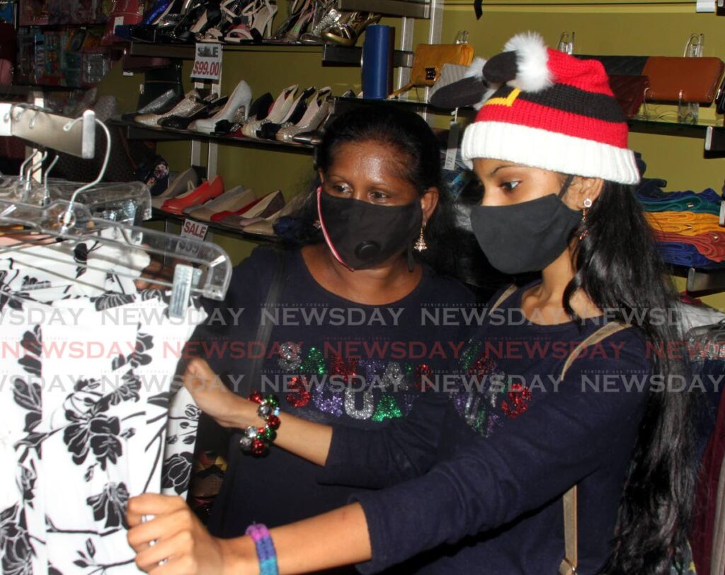 Mother and daughter Carol and Leaza-Anji Joseph wore matching Christmas sweaters while shopping in Port of Spain on Thursday. - Angelo Marcelle