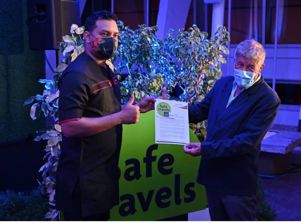 Minister of Tourism, Culture and the Arts Randall Mitchell,  presents the World Travel and Tourism Council (WTTC) Safe Travel Stamp to Queen's Hall  chairman Dr Helmer Hilwig. - 