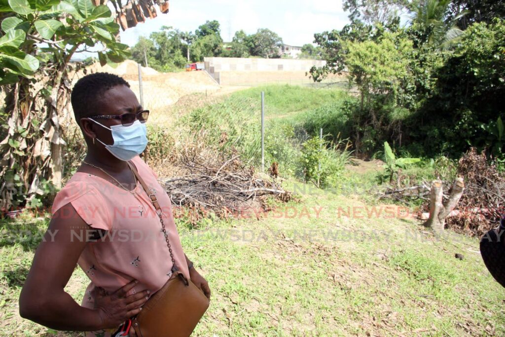 Jillian Williams stands next to the fallen fence at her Pepper Village, Fyzabad home. Wiilliams says that a contractor working on the highway damaged her fence and that she has been waiting months for the person to have it replaced. - Lincoln Holder