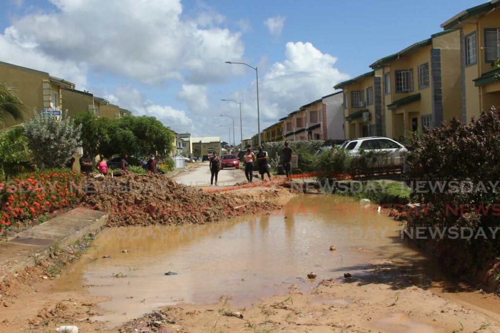 Oasis Greens, Chaguanas, residents complain about the slow pace of repair of a damaged road and sewage line at Calistoga Drive, on Sunday. - Marvin Hamilton