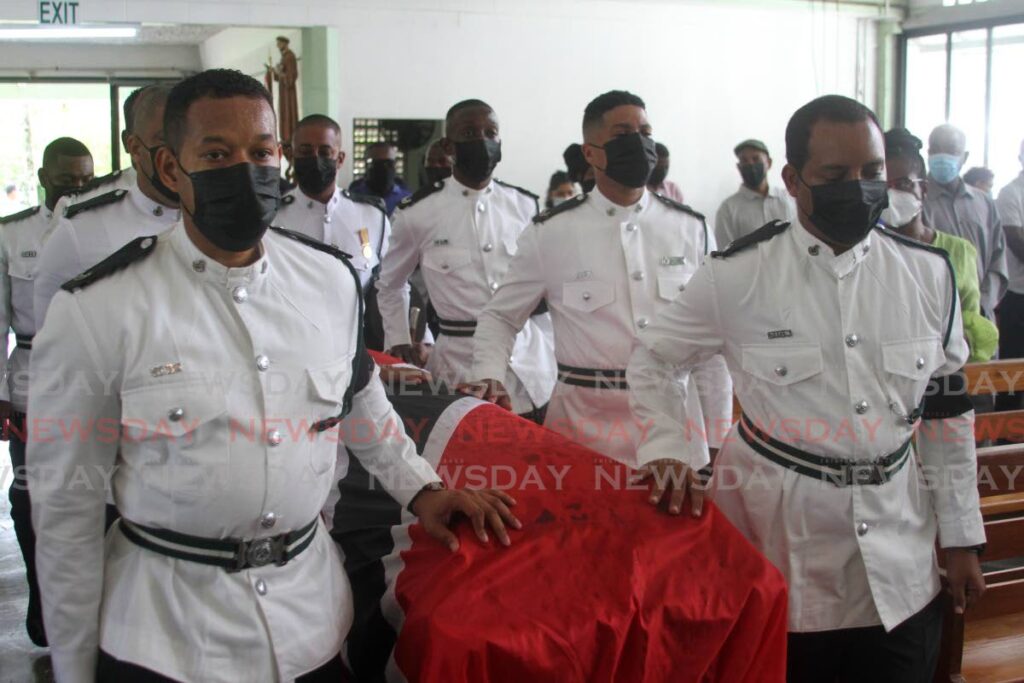 Prison officers take the casket of their murdered colleague Trevor Serrette into the St Francis RC Church in Sangre Grande at the start of his funeral on Monday. - Angelo Marcelle