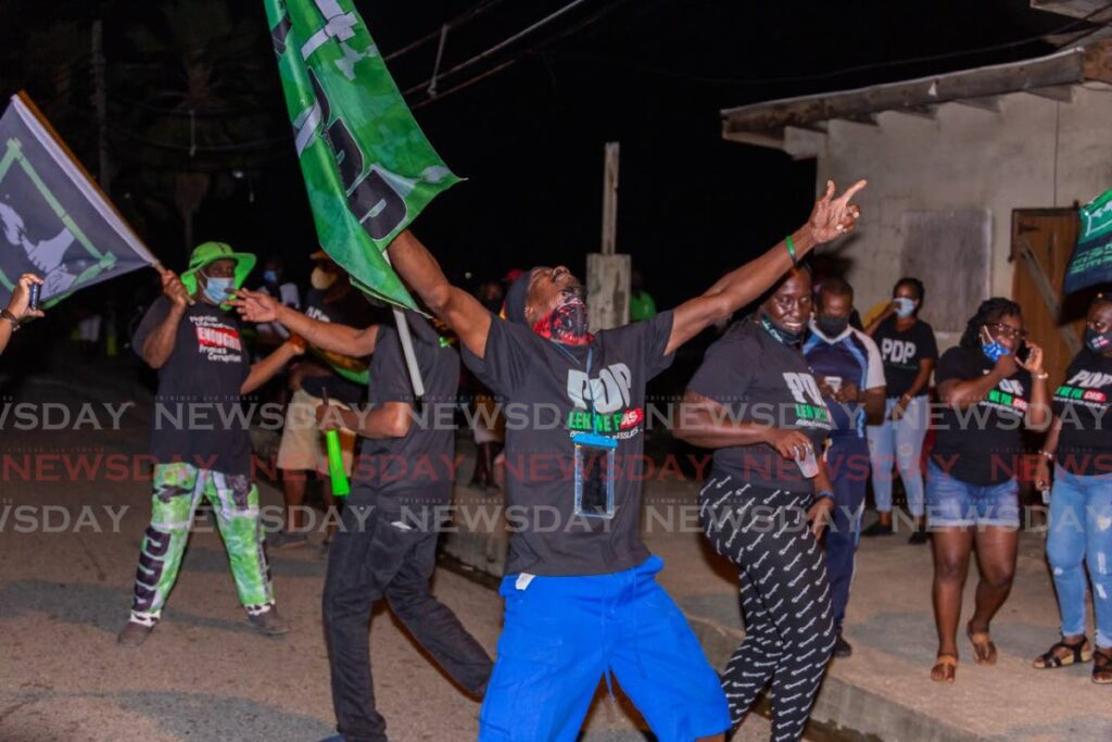 PDP supporters celebrate at their party's headquarters in Roxborough, Tobago on Monday night. - David Reid