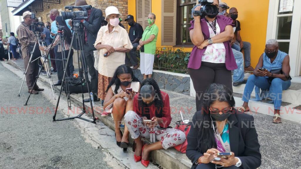 Media workers covering the inaguration ceremony of THA secretaries at the Assembly Legislature Building in Scarborough, Tobago take to the pavement after being escorted off the compound by police. - Photo by Jeff K Mayers 
