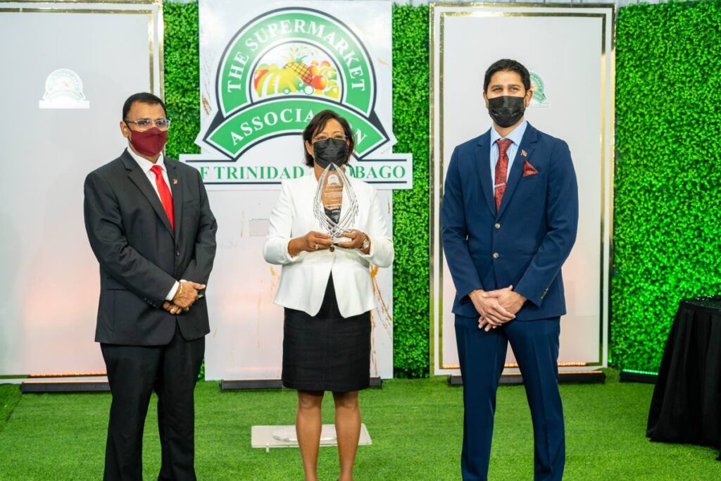 Works and Transport Minister Rohan Sinanan, left, Maria Roodal, Key Account Merchandising Manager, Associated Brands Industries Ltd, centre, and Rajiv Diptee, president of the Supermarket Association at the association's 27th annual awards ceremony. 

  - 