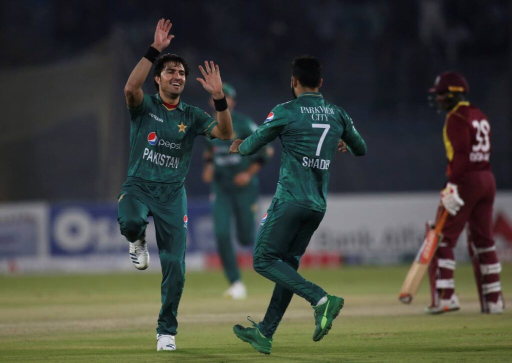 Pakistan's Mohammad Wasim, left, celebrates with teammate Shahdab Khan, centre, after taking the wicket of West Indies captain Nicholas Pooran during the first Twenty20 at the National Stadium, in Karachi, Pakistan, on Monday. (AP Photo) - 