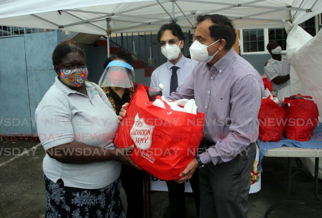 Over 1000 Christmas hampers were distributed to the needy at the Salvation Army Headquarters Henry Street in Port of Spain. Isadora Dominique (left) received her hamper from Coosal's Group of Companies chairman Sieunarine Coosal, Salvation Army board member, Shivan Bhaggan, and patron Zalayhar Hassanali. - Photo by Sureash Cholai