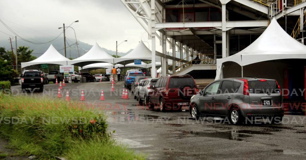 There was a steady flow of vehicles with persons coming for their 3rd dose booster covid 19 vaccine at the drive through of the Hasely Crawford Stadium. - Photo by Sureash Cholai