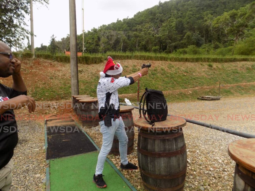 A man wearing a Santa Claus hat takes aim during a sharpshooting tournament at the MH Tactical Response Group, Chaguaramas, last Saturday - Shane Superville