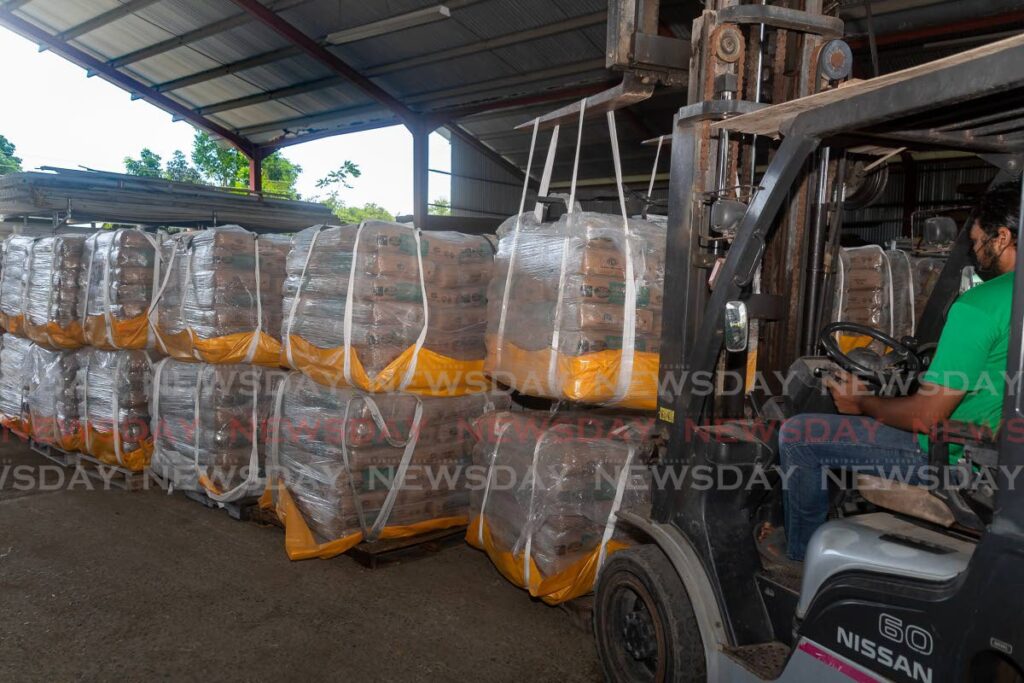 Brandon Kissoon of Kissoon's Hardware, Canaan, Tobago, stocks pallets of TCL cement on Wednesday. TCL's price increases take effect from Monday. - Photo by David Reid