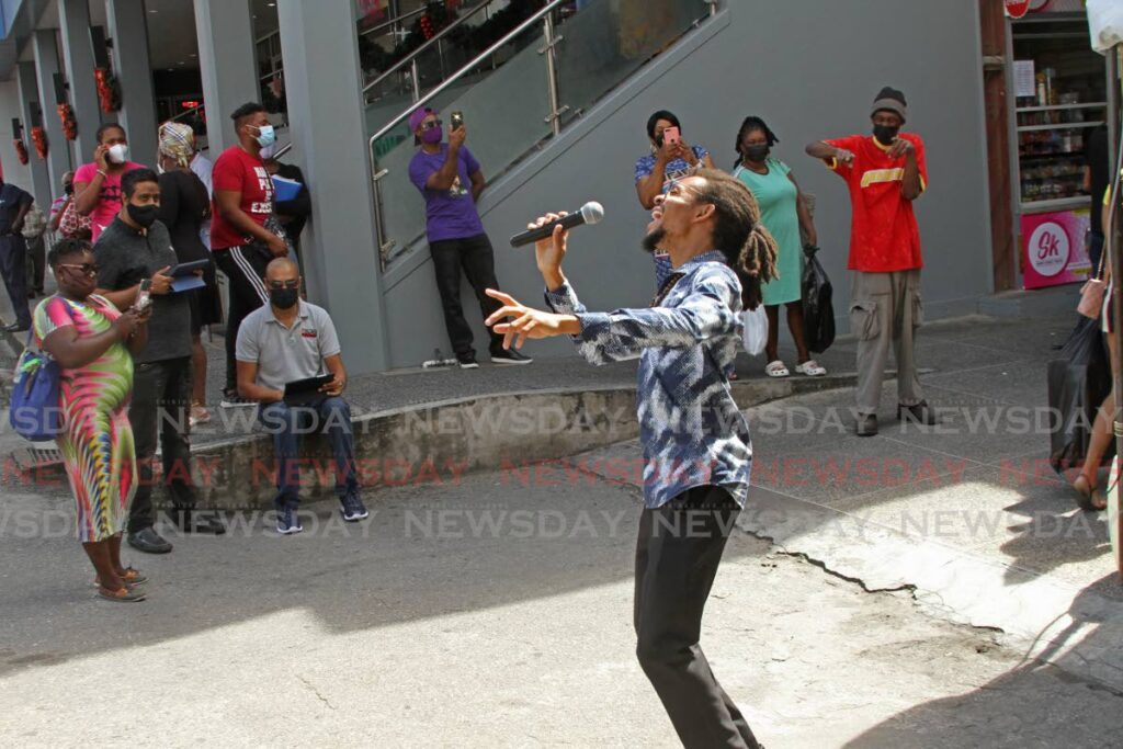 A La Mansion Music singer serenades shoppers in San Fernando. - PHOTO BY MARVIIN HAMILTON